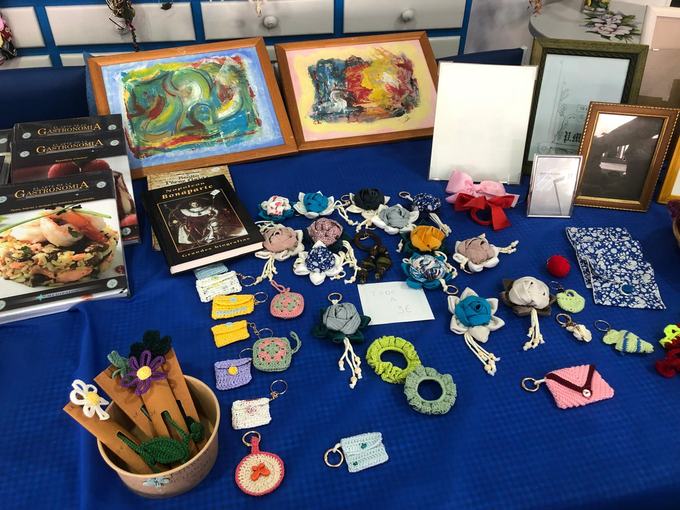 Mesa de libros, cuadros y artesanía solidaria